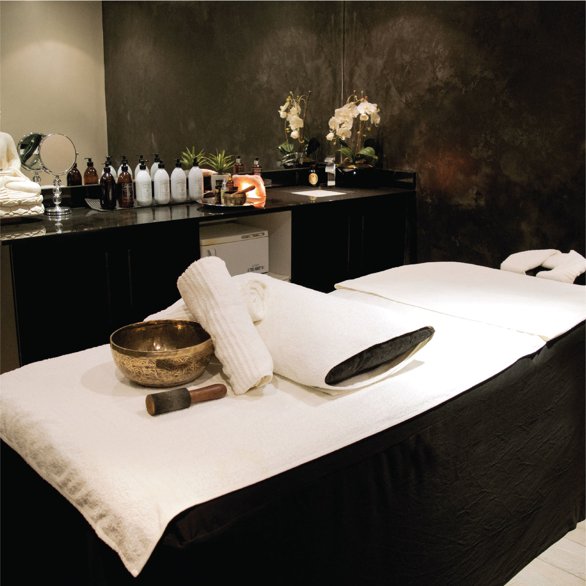 Professional luxury spa treatment room with massage bed and spa products